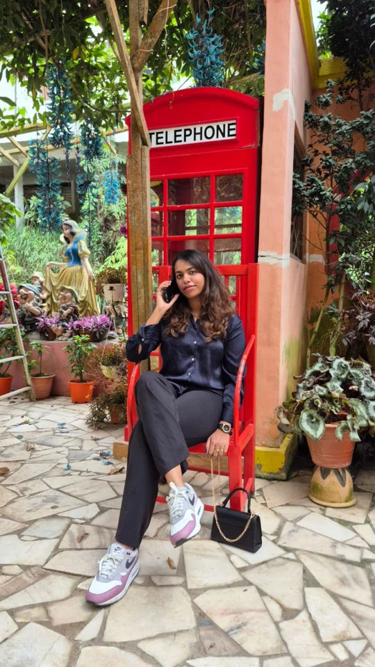 Vansita sitting beside a red telephone booth
